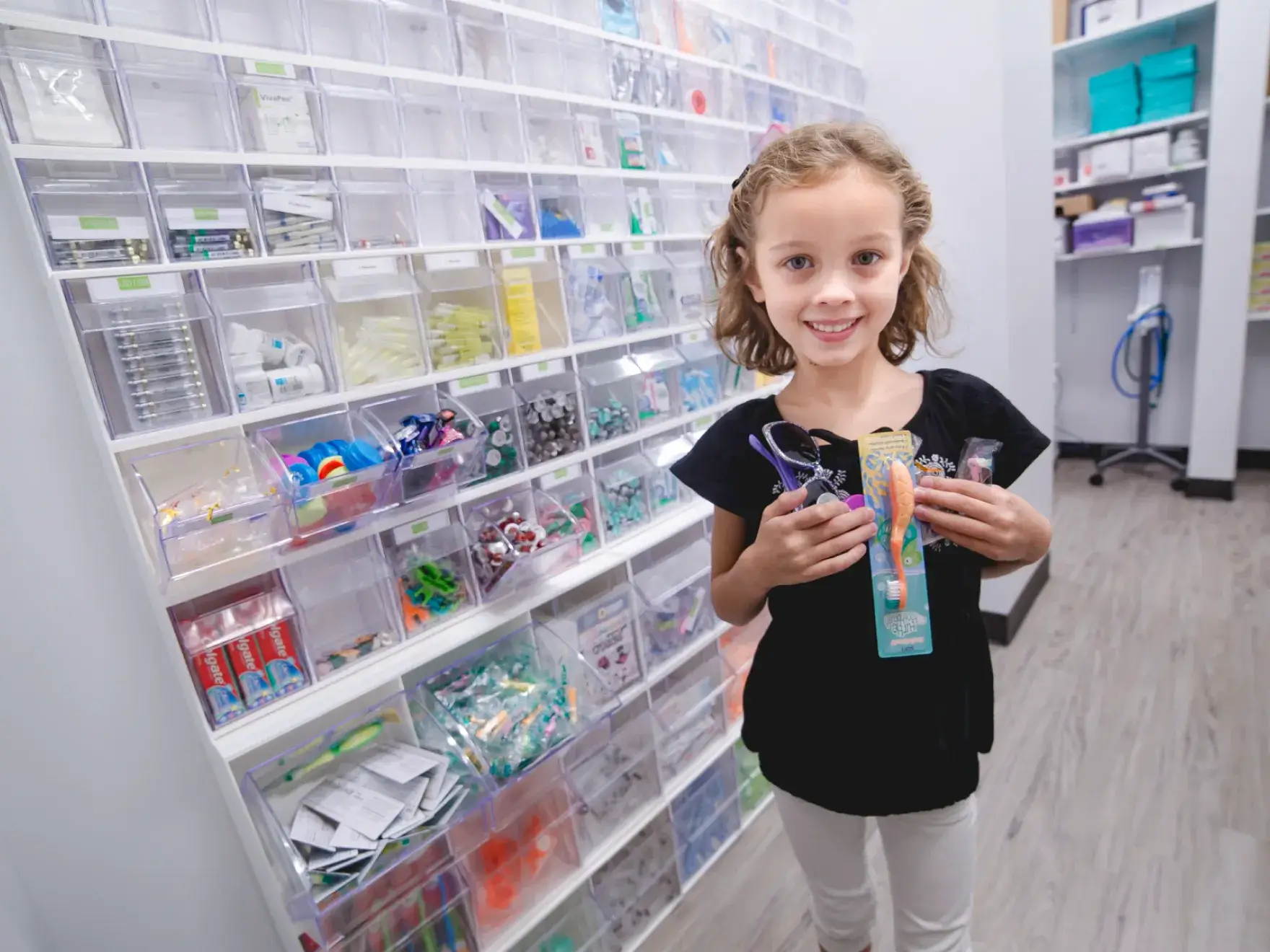 A young girl holding a toothbrush in a store.
