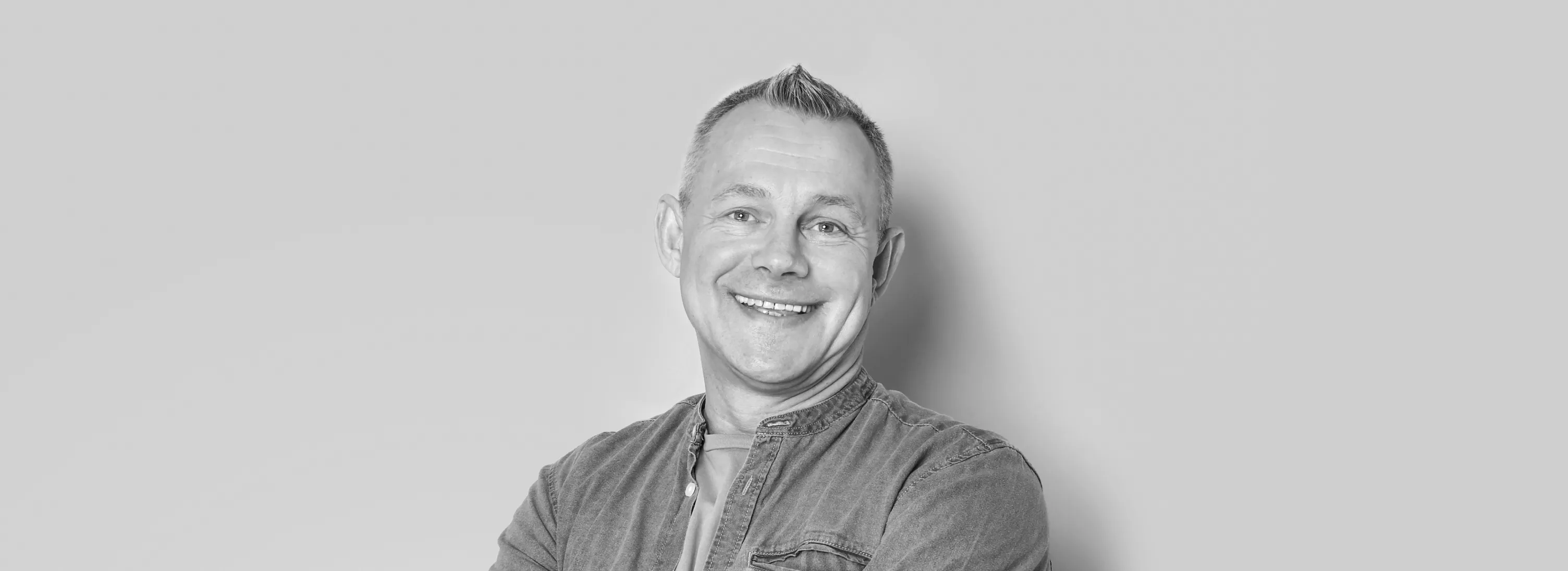 a black and white photo of a man smiling