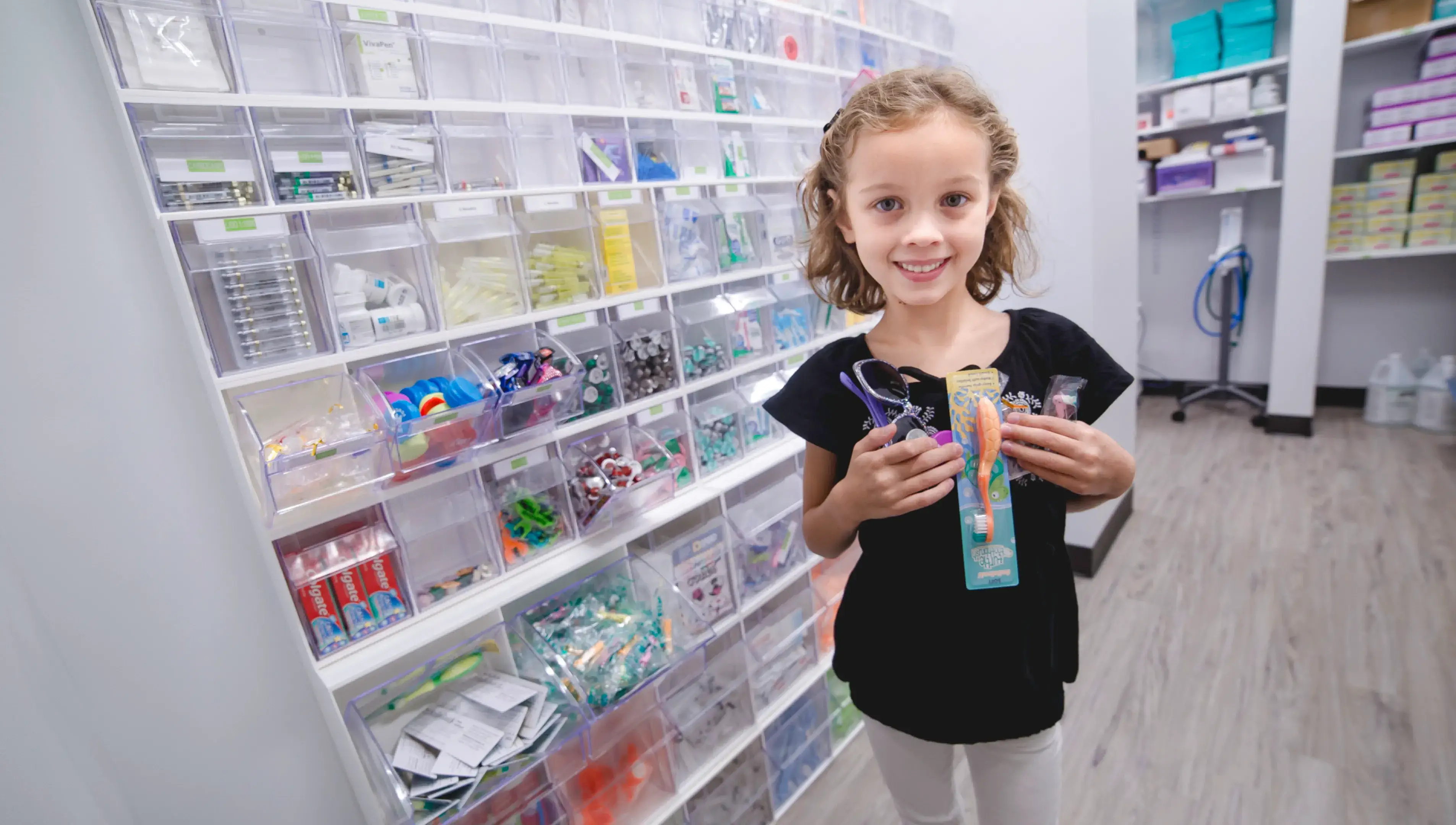 A young girl holding a toothbrush in a store.