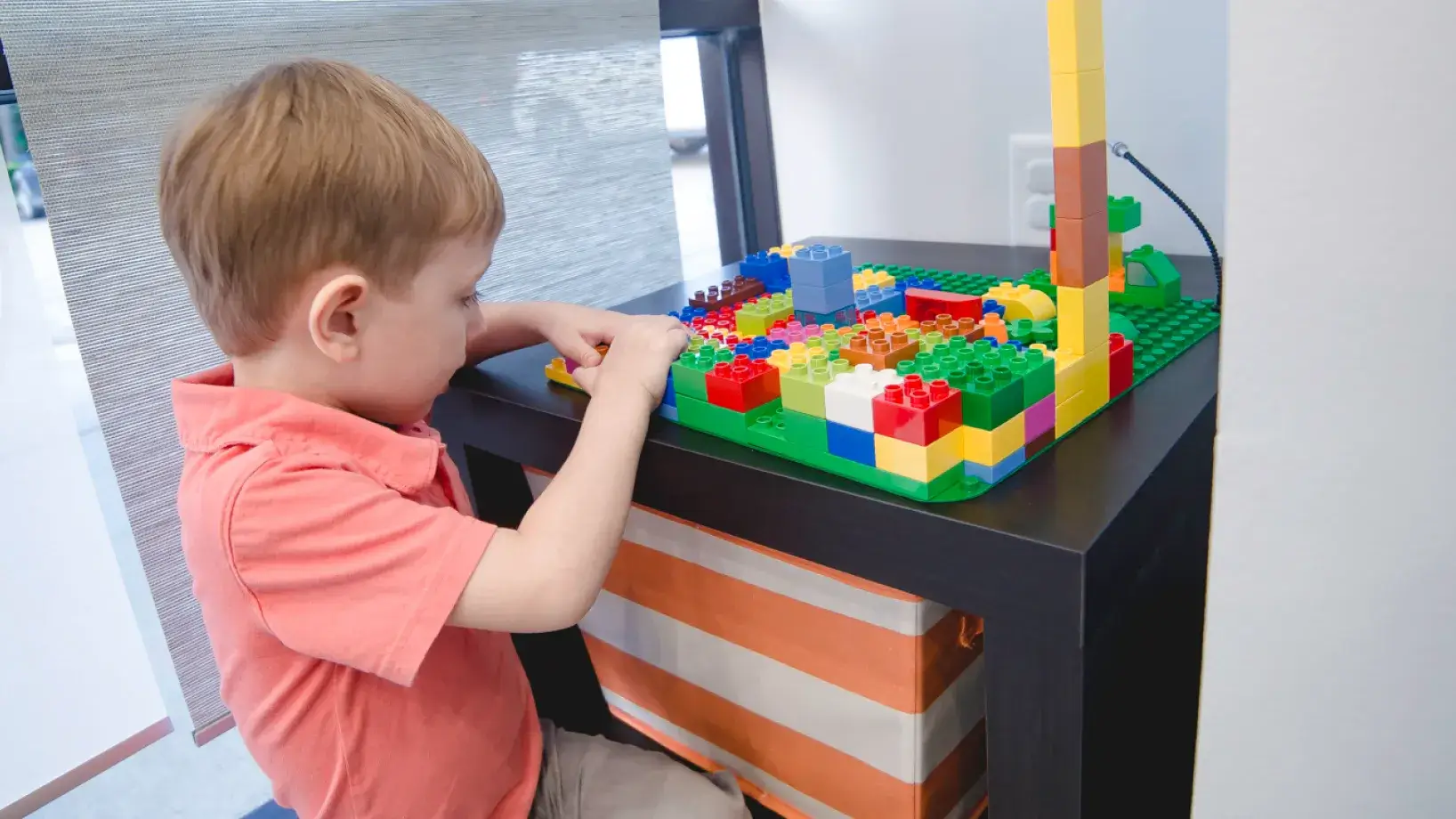 A young boy playing with a lego set.