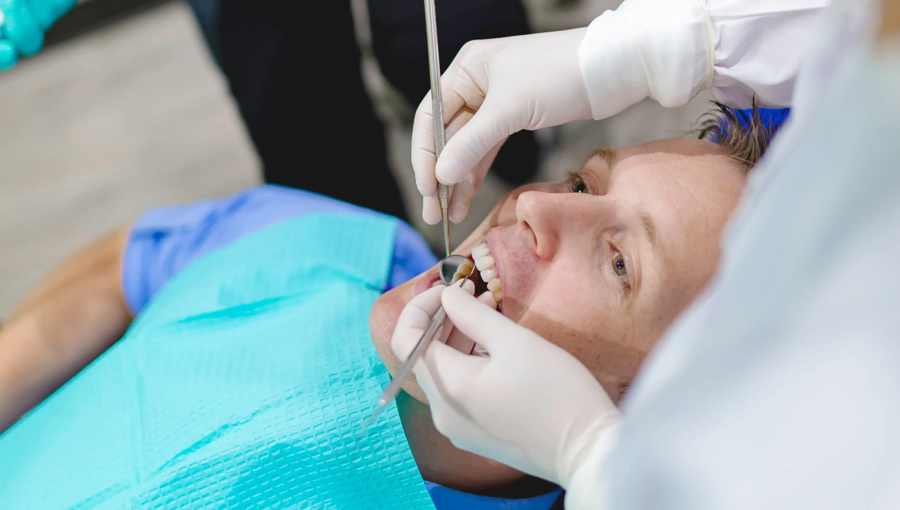 A woman getting her teeth checked by a dentist.