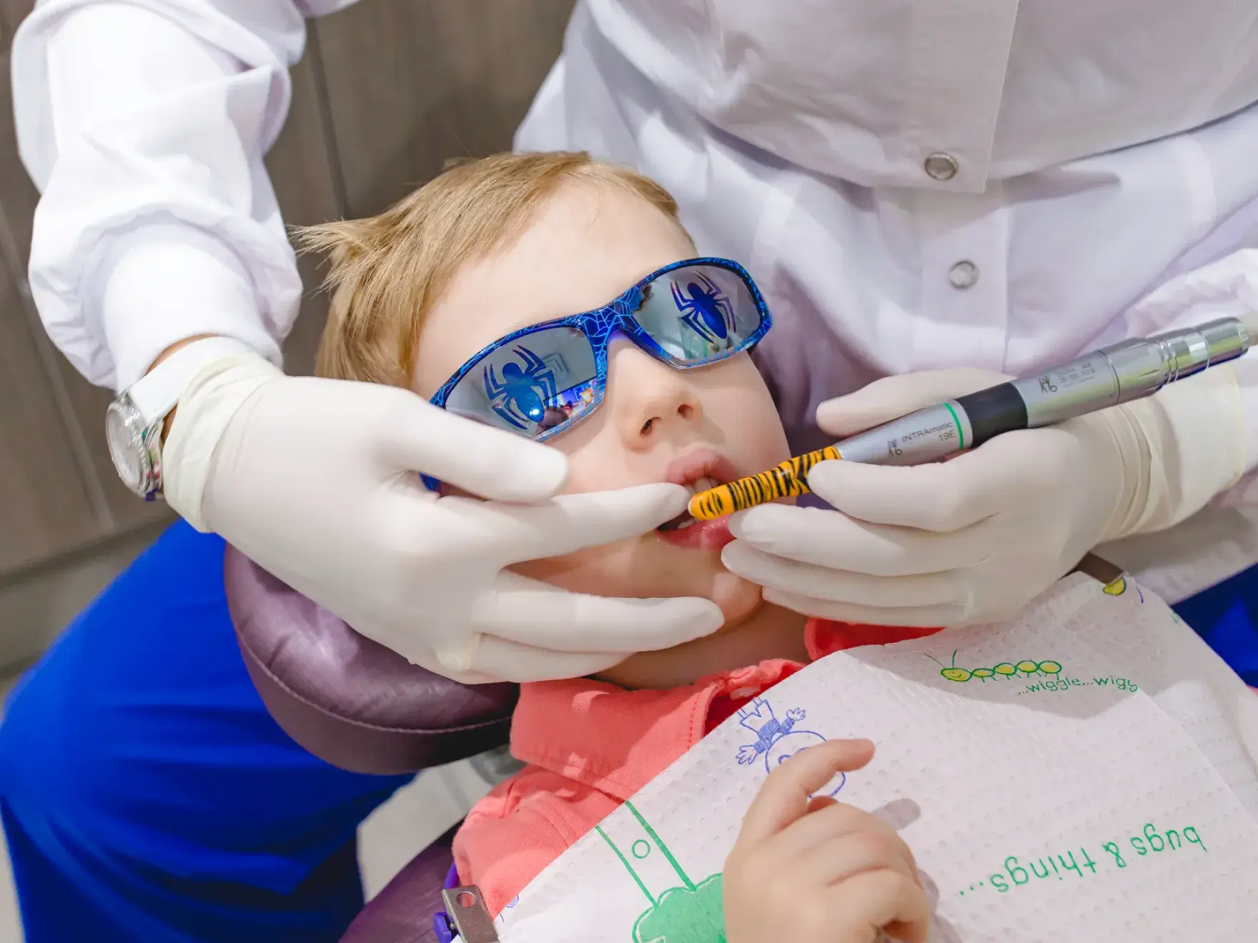 A little boy getting his teeth checked by a dentist.