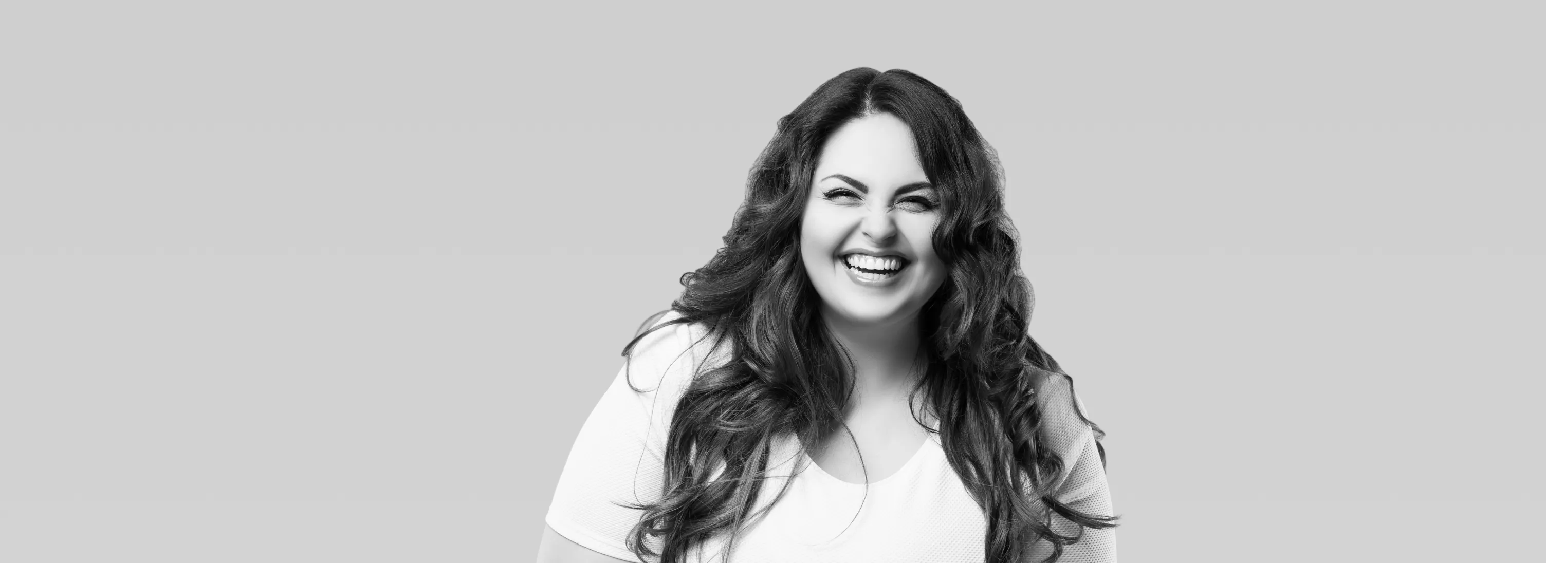 a black and white photo of a woman smiling