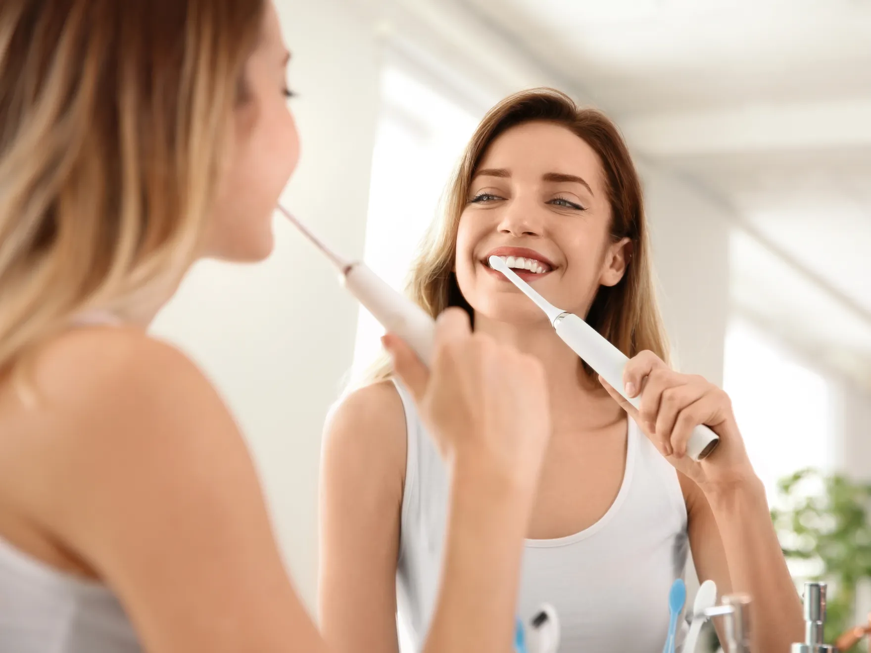 a woman brushing her teeth in front of a mirror