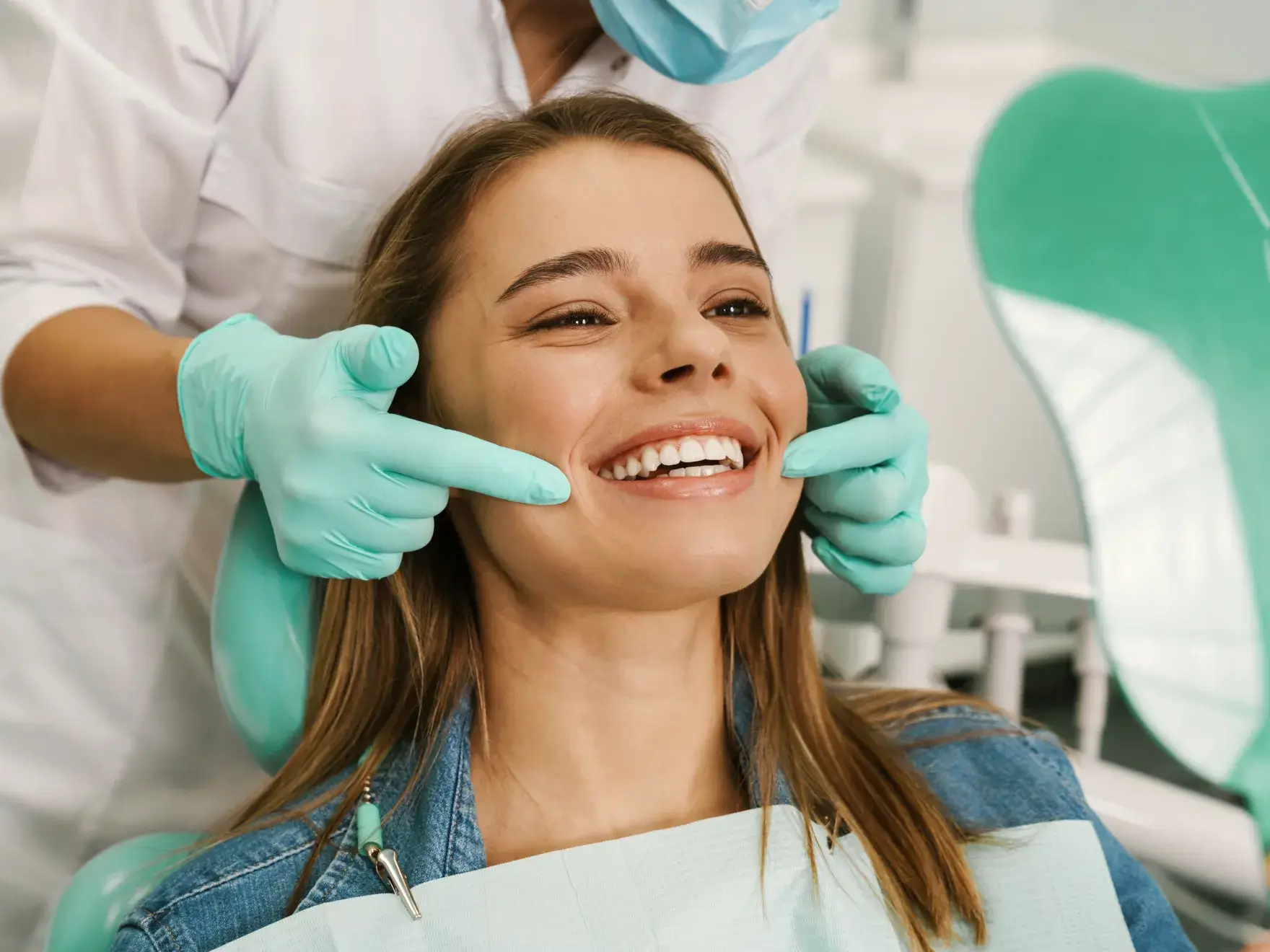 a woman getting her teeth brushed by a dentist